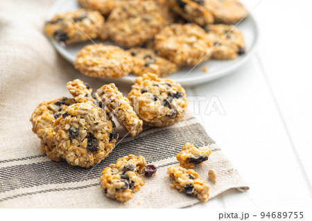 Wholegrain oat cookies. Cookies with oatmeal and raisins on white table. 94689755