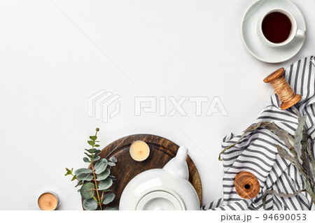 Still life with tea cup and the contents of a workspace composed. Different objects on white table. Flat lay 94690053