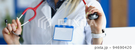 Female medical worker in white uniform posing with stethoscope on neck 94690420