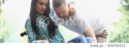 Man husband take woman in arms, disabled wife on wheelchair Man husband take woman in arms, disabled wife on wheelchair 94690431