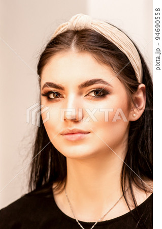 The fashionable young woman. Portrait of the beautiful female model with long hair and makeup. Beauty young caucasian woman with a hoop on her head The fashionable young woman. Portrait of the beautiful female model with long hair and makeup. Beauty young caucasian woman with a hoop on her head 94690558