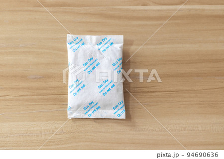 Desiccant silica on the pack. Closeup view. packet of silica gel buried in silica crystals, Written do not eat 94690636