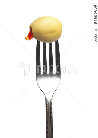 Green olives stuffed with sweet peppers on a fork isolated on a white background 94690699