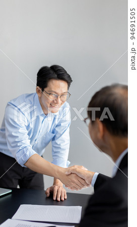 Businessman shaking hands with a lawyer or judge After signing the contract and the agreement is complete, Approval of an agreement between business and law, End of the legal case. Businessman shaking hands with a lawyer or judge After signing the contract and the agreement is complete, Approval of an agreement between business and law, End of the legal case. 94691505