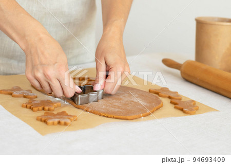Women's hands prepare homemade traditional New Year's cookies snowflake gingerbread man Women's hands prepare homemade traditional New Year's cookies snowflake gingerbread man 94693409