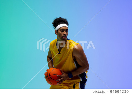 Image of biracial basketball player with basketball on green to blue background Image of biracial basketball player with basketball on green to blue background 94694230