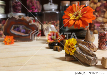 Agatized Coral With Quartz Crystals and Flowers on Meditation Table 94694555