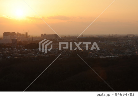 夕日とビル建設現場の遠景 夕日とビル建設現場の遠景 94694783