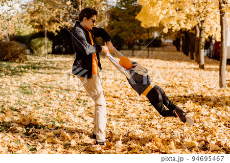 Father and son having fun in autumn park with fallen leaves, throwing up leaf. Child kid boy and his dad outdoors playing with maple leaves. Father and son having fun in autumn park with fallen leaves, throwing up leaf. Child kid boy and his dad outdoors playing with maple leaves. 94695467