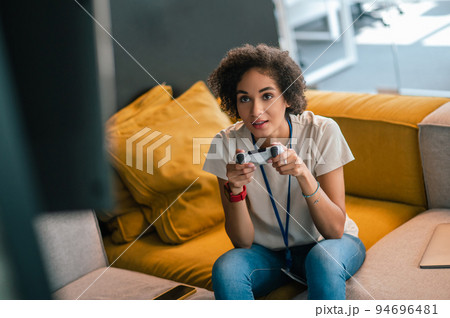 Young girl in white tshirt playong on playstation Young girl in white tshirt playong on playstation 94696481