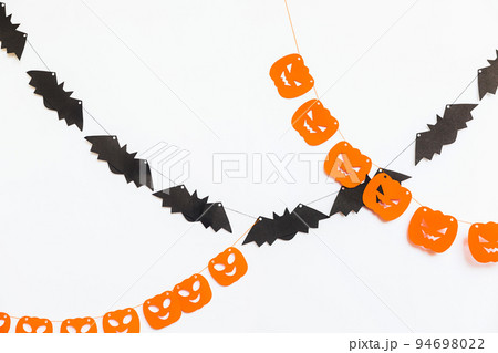 Trick or Treat concept. Holiday composition with halloween garland decorations pumpkins and bats isolated on white background. Preparation for Halloween party. Autumn fall happy Halloween. Trick or Treat concept. Holiday composition with halloween garland decorations pumpkins and bats isolated on white background. Preparation for Halloween party. Autumn fall happy Halloween. 94698022
