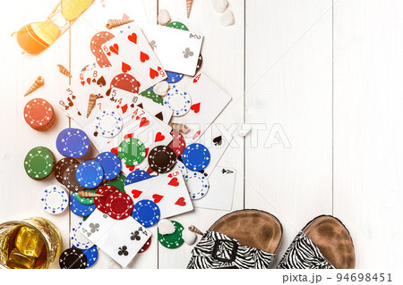 Gambling. Poker chips, cards, sunglasses and flip-flops on wooden table. Top view. Copyspace. Poker 94698451