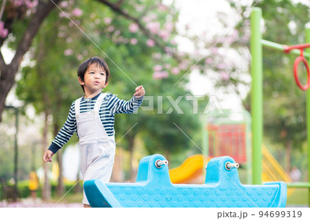 Adorable little boy playing in colorful outdoor playground Adorable little boy playing in colorful outdoor playground 94699319