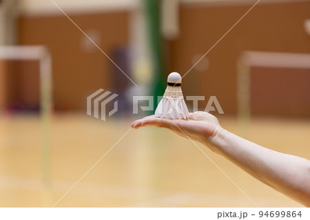 女性の手のひらの上にのせているバドミントンのシャトル 94699864