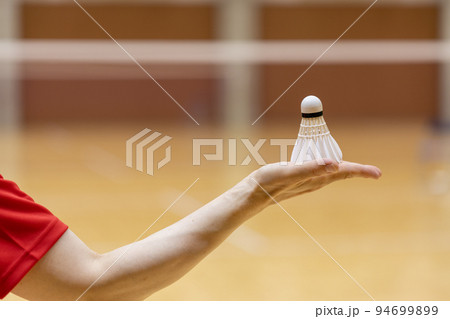 女性の手のひらの上にのっているバドミントンのシャトル 94699899