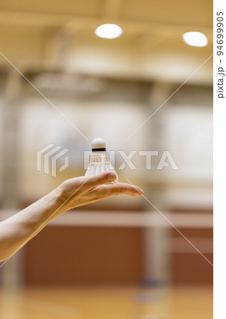 女性の手のひらの上にのっているバドミントンのシャトル 94699905