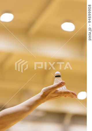 女性の手のひらの上にのっているバドミントンのシャトル 94699908