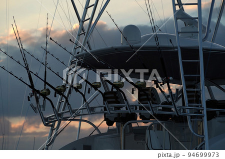 detail of many fishing rod on a boat at sunset 94699973