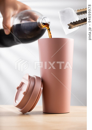 Putting soft drink into a tumbler Putting soft drink into a tumbler 94699978