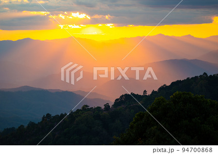 Dramatic sunset over mountain ranges with orange sunlight. 94700868