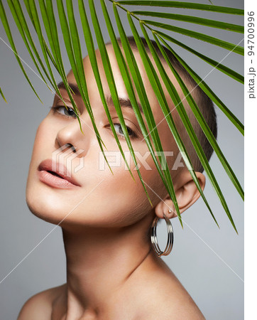 beautiful bald girl in palm leaves. Beautiful young short hair woman 94700996