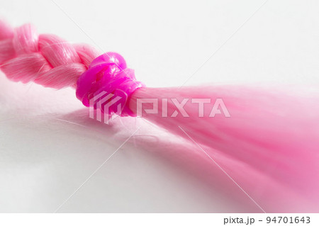 Pink pigtail from a doll on a white background, isolate. Close-up Pink pigtail from a doll on a white background, isolate. Close-up 94701643