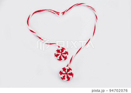 knitted red white round candy caramel two pieces laid out in shape of heart on white background, concept of love knitted red white round candy caramel two pieces laid out in shape of heart on white background, concept of love 94702076