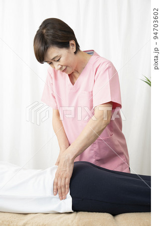 腰のマッサージをする整体師の女性 94703602
