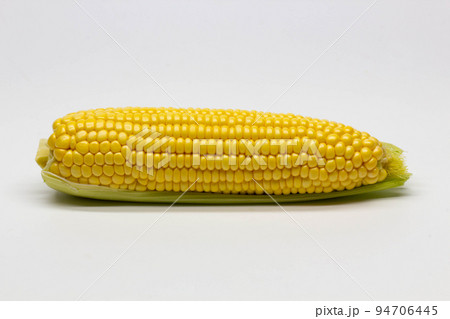 Single ear of corn isolated on white background. Isolated. Package design element. Sweet corn with husk. Close-up Single ear of corn isolated on white background. Isolated. Package design element. Sweet corn with husk. Close-up 94706445