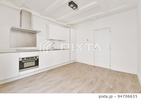 Interior of empty white kitchen with windows and wooden parquet floor 94706635