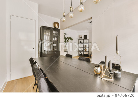 Contemporary minimalist style interior design of light studio apartment with wooden table and chairs in dining zone in living room with white walls and parquet floor Contemporary minimalist style interior design of light studio apartment with wooden table and chairs in dining zone in living room with white walls and parquet floor 94706720