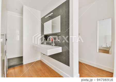 Sink with tap and liquid soap hanging on tiled wall under mirror in contemporary restroom at home Sink with tap and liquid soap hanging on tiled wall under mirror in contemporary restroom at home 94706916