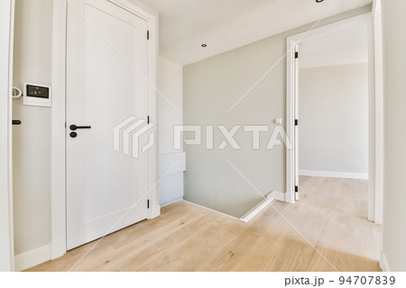 Interior of contemporary flat in minimal style with spacious hallway with white walls Interior of contemporary flat in minimal style with spacious hallway with white walls 94707839