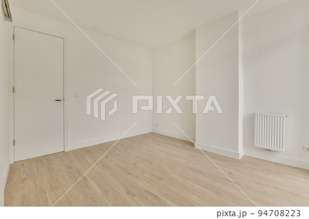 Interior of empty white room with large balcony windows with curtains and wooden parquet floor 94708223