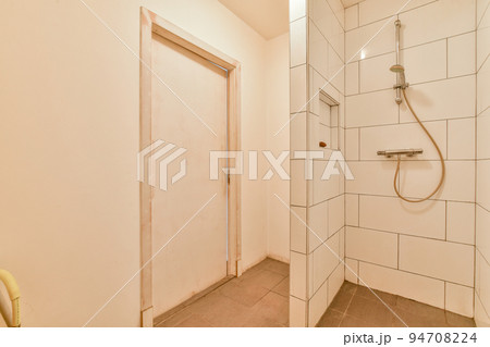 Fragment of interior of modern white bathroom with wooden cabinet under sink and with mirror and towel Fragment of interior of modern white bathroom with wooden cabinet under sink and with mirror and towel 94708224