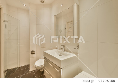 Interior of cozy bathroom with rectangular mirror and clean sinks in washroom 94708380