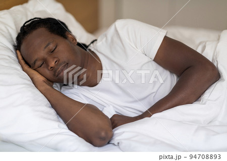 Portrait Of Calm Young Black Man Sleeping In Comfortable Bed At Home 94708893