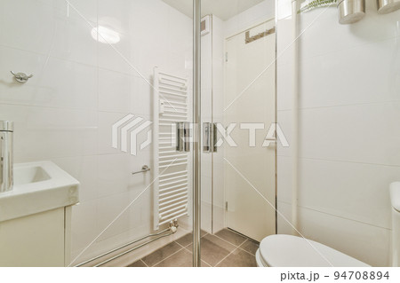 Flush toilet located between sink and shower bathroom of contemporary apartment Flush toilet located between sink and shower bathroom of contemporary apartment 94708894