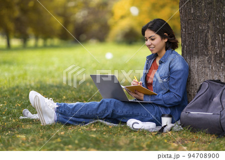 Remote Lesson. Beautiful Young Arab Female Student Study Outdoors With Laptop 94708900