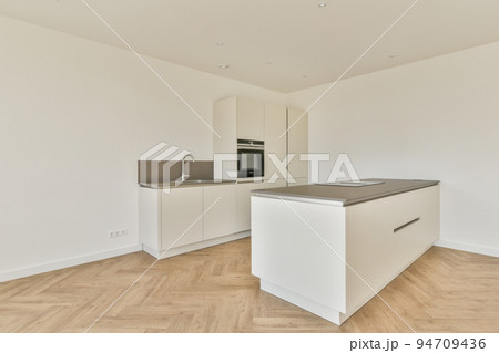 Interior of empty white kitchen with windows and wooden parquet floor 94709436