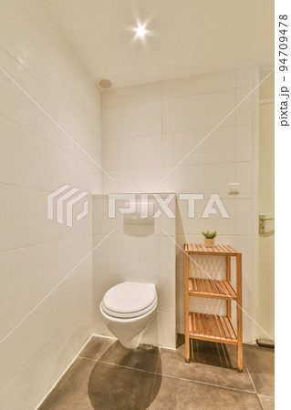 Modern home interior design of white bathroom with open bathtub and shower separated from toilet by partition wall 94709478