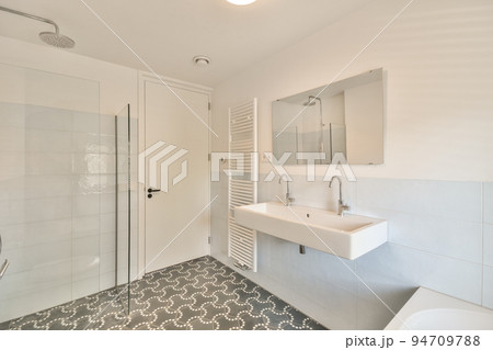 Modern home interior design of white bathroom with open bathtub and shower separated from toilet by partition wall Modern home interior design of white bathroom with open bathtub and shower separated from toilet by partition wall 94709788