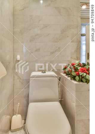 Modern home interior design of white bathroom with open bathtub and shower separated from toilet by partition wall 94709849