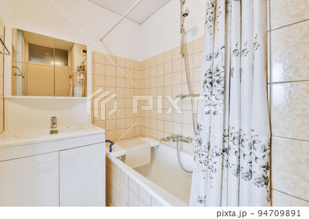 White ceramic sink and mirror with illumination in bathroom designed in minimal style White ceramic sink and mirror with illumination in bathroom designed in minimal style 94709891