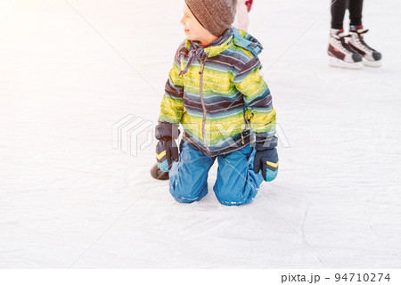 Soft,Selective focus.Funny moment fell on the ice skating rink.A kids takes relax after his fall while skating. Holiday and seasonal concept.Group of teenage friends ice skating on an ice rink. Soft,Selective focus.Funny moment fell on the ice skating rink.A kids takes relax after his fall while skating. Holiday and seasonal concept.Group of teenage friends ice skating on an ice rink. 94710274