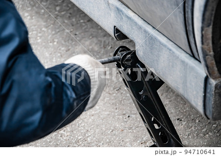Auto mechanic changes wheel on old car. Auto mechanic changes wheel on old car. 94710641
