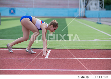 Female runner in the stadium is ready to race. Female runner in the stadium is ready to race. 94711206
