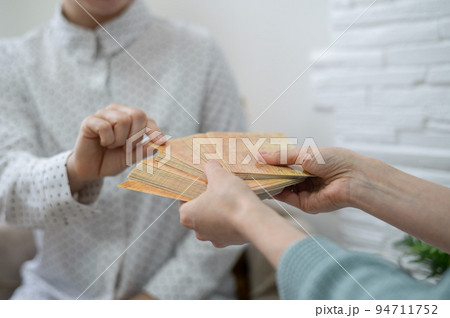 Psychologist uses metaphorical associative cards in a session with a patient. Close-up of female hands. 94711752