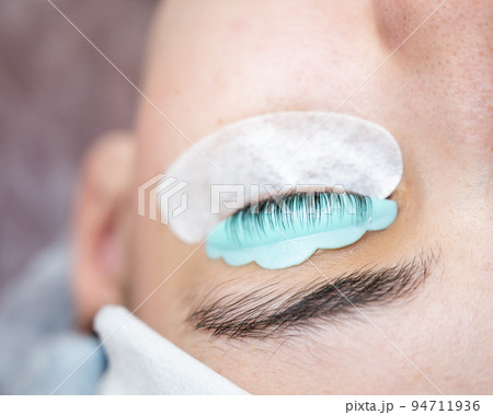 Close-up portrait of a woman in a beauty salon on eyelash lamination procedure.  94711936