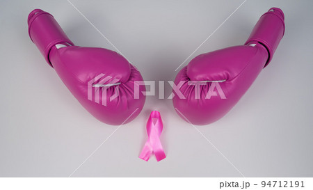 Pink boxing gloves and a pink silk ribbon on a white background. Breast cancer concept.  94712191